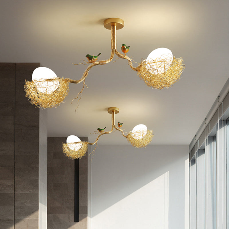 Lampadario dorato con globo in vetro bianco latte e uccelli
