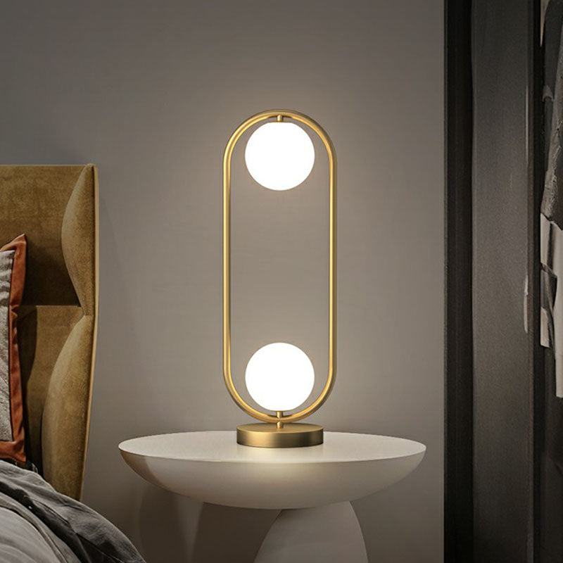 Lampada da tavolo con 2 sfere - finitura dorata con paralume in vetro e struttura ovale