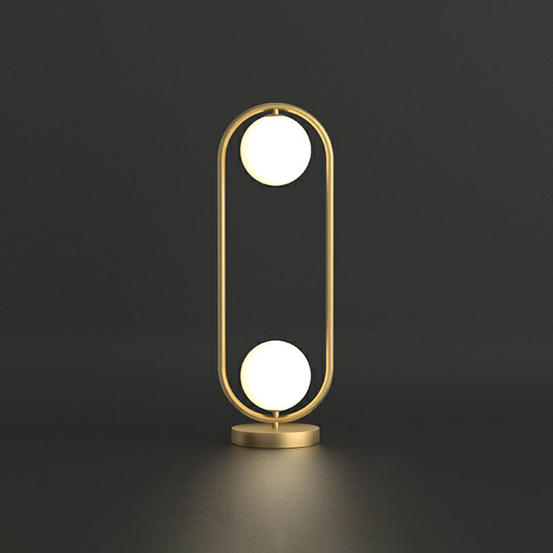 Lampada da tavolo con 2 sfere - finitura dorata con paralume in vetro e struttura ovale