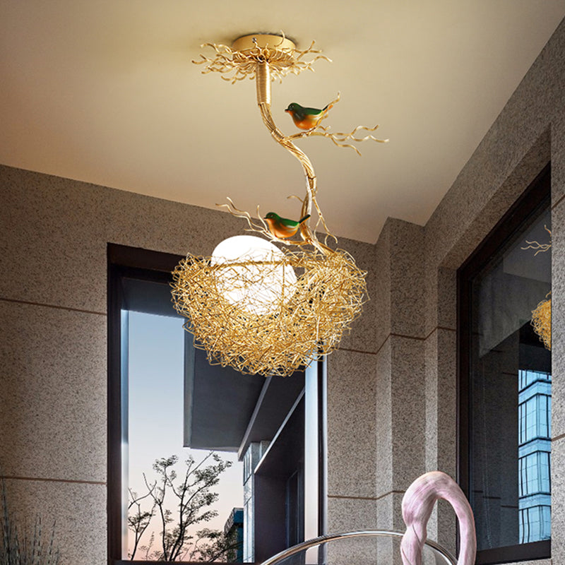 Lampadario dorato con globo in vetro bianco latte e uccelli