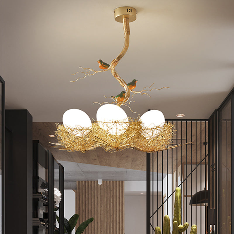 Lampadario dorato con globo in vetro bianco latte e uccelli